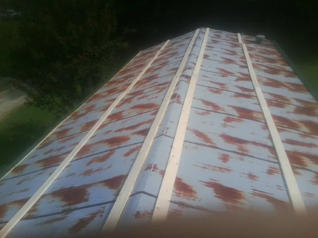 Rusted metal roof panels with new wood purlins before replacement — Storm Damage Roof Repair in Lowman by Roofing Brothers