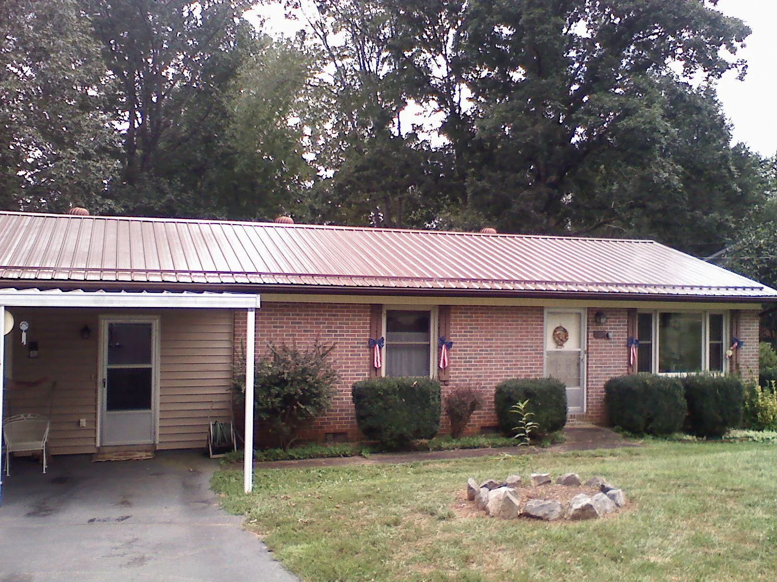 Bronze metal roof and carport on a brick ranch home — Roof Repair work by our crew in Lowman