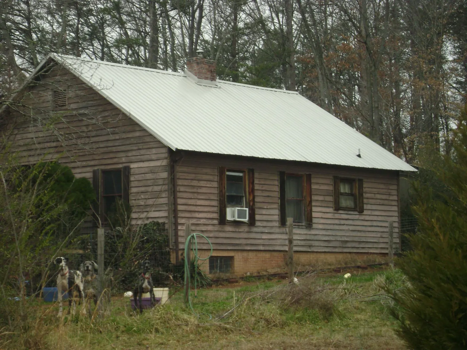 White metal roof on an old wood sided farmhouse, from a Metal Roof Installation job in Lowman